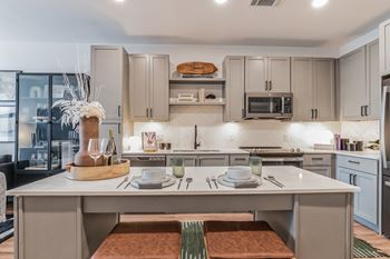 A kitchen with an island and a table with plates and utensils